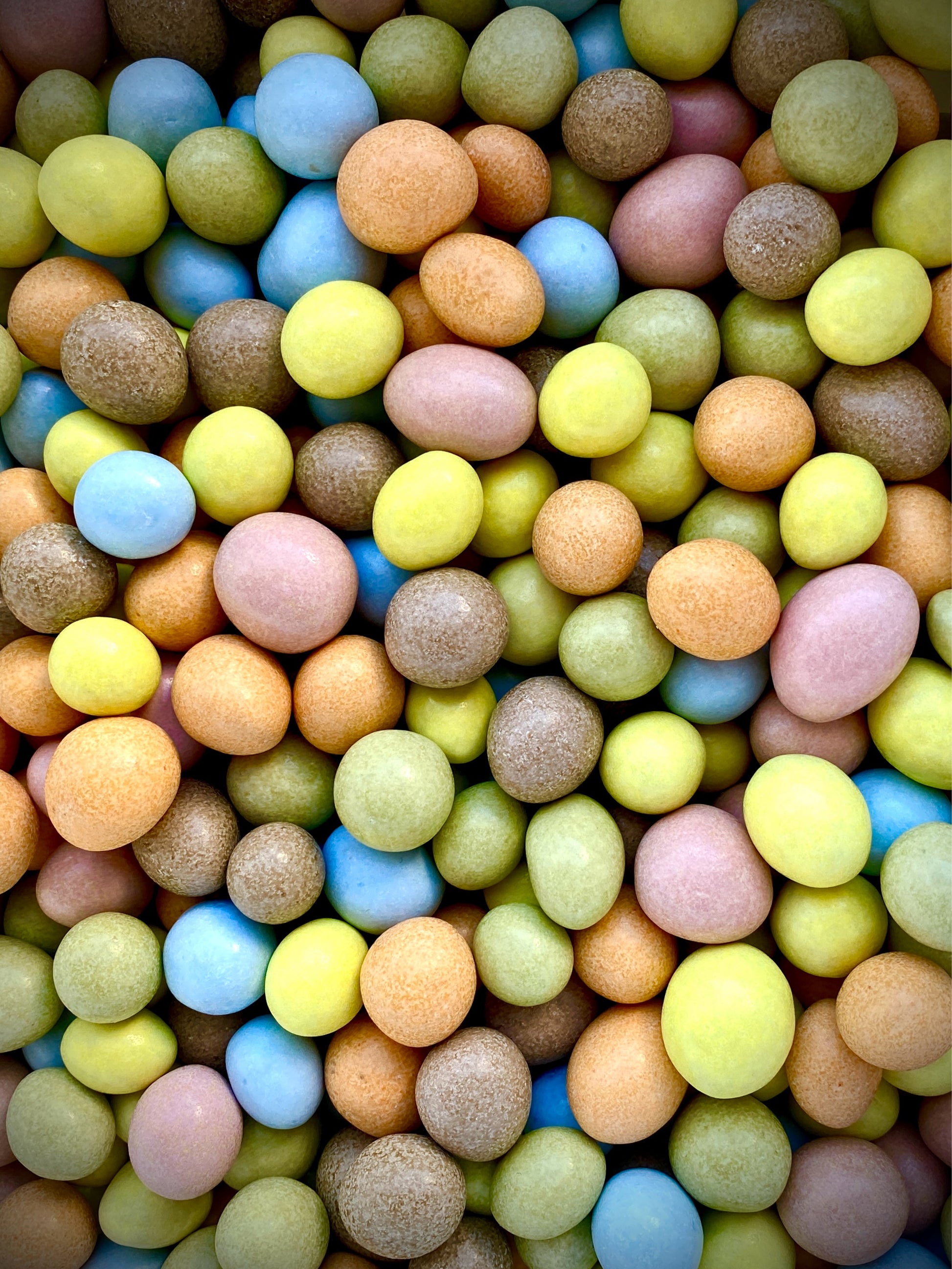 Vue rapprochée des Coq’n Choc artisanaux bio montrant leur texture croquante et leur enrobage coloré naturel.