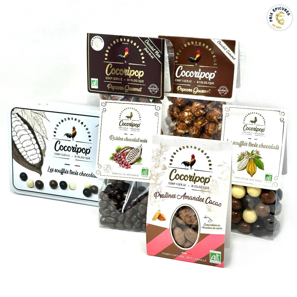 Pack Grand Mix Tout Chocolat Bio – assortiment gourmand de chocolats artisanaux incluant coffret métal trois chocolats, popcorn chocolat noir et caramel, soufflés trois chocolats, raisins chocolat noir et pralines amandes cacao, présenté sur fond blanc. bio
