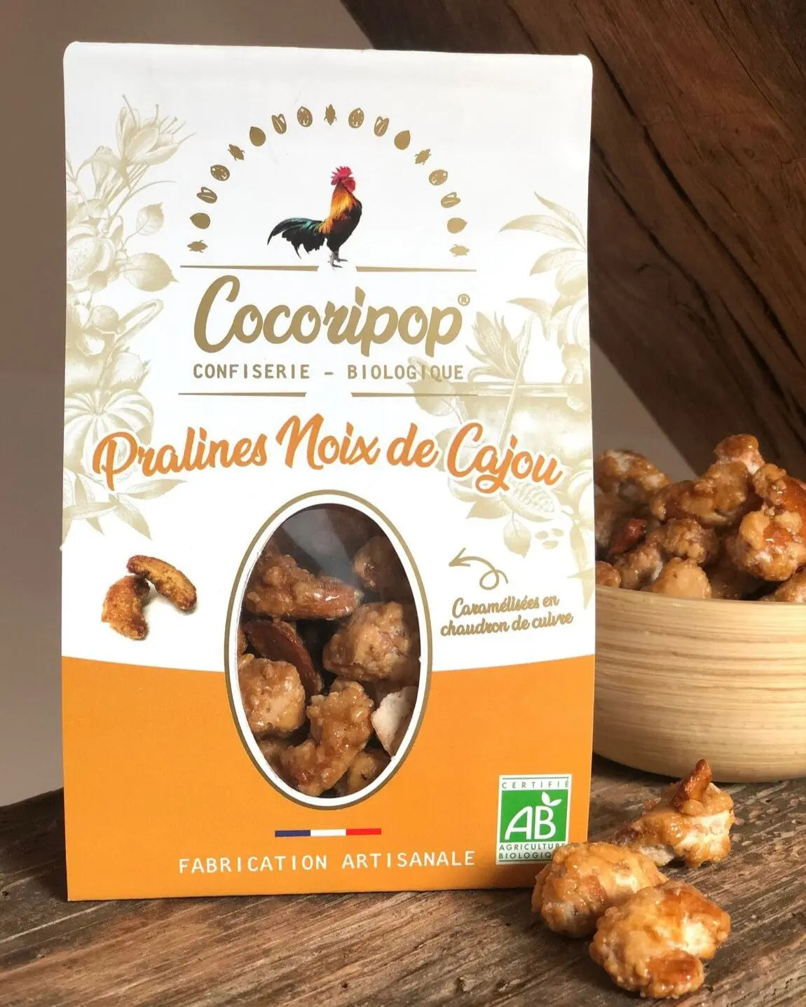 Pralines Noix de Cajou Bio  – un parfait équilibre entre le croquant des noix de cajou torréfiées et la douceur du caramel doré. Une mise en scène élégante pour une confiserie artisanale et gourmande. bio