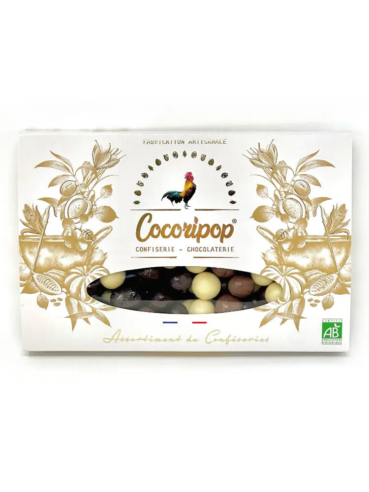 Coffret Noisette Trio Chocolat – assortiment de chocolats au lait, noir et blanc, sur fond blanc.Coffret gourmand de noisettes enrobées de chocolat noir, au lait et blanc, présenté sur fond blanc.Coffret Noisette Trois Chocolats – chocolats artisanaux au lait, noir et blanc, par Cocoripop.Coffret artisanal de noisettes croquantes enrobées de chocolat noir, lait et blanc. BIO