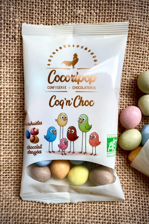 Cacahuetes croquantes enrobees de chocolat noir et lait, drageifiees en pigments vegetaux. La version bio et artisanale des celebres MMs.