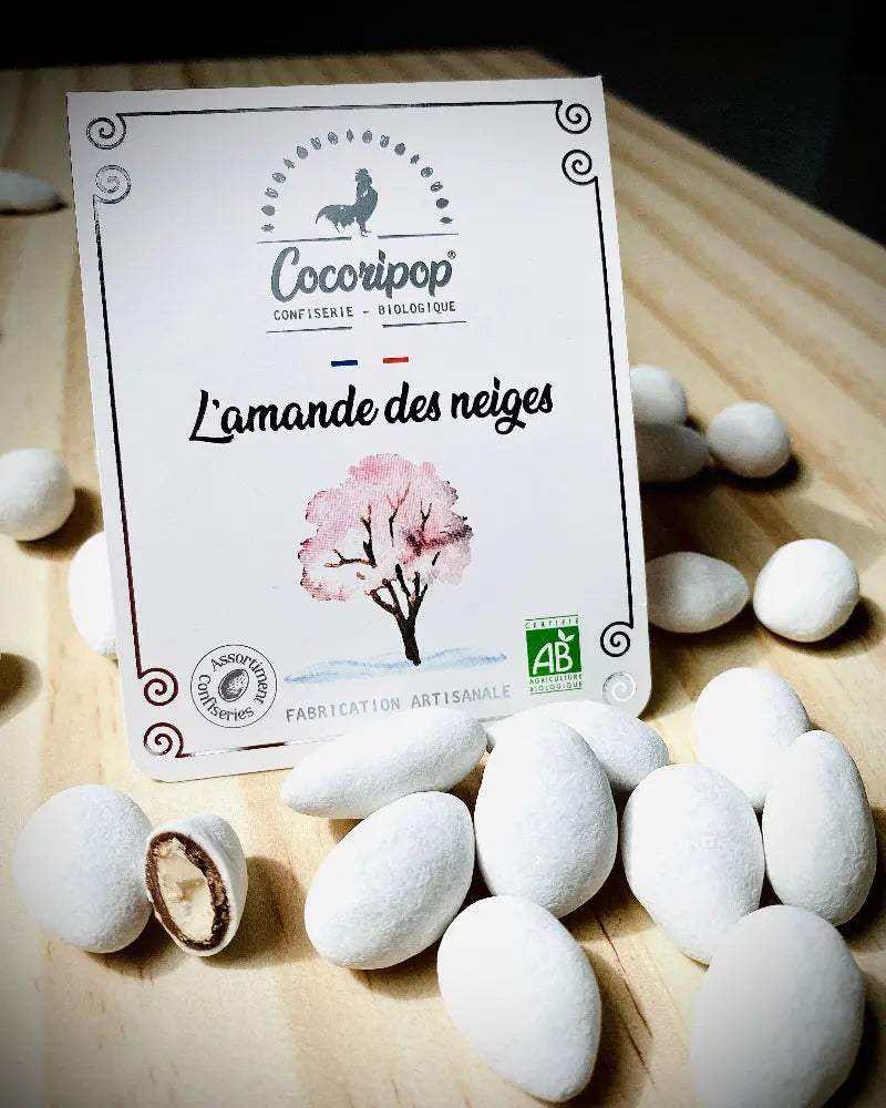 l'amande des neiges bio  – gourmandise raffinée alliant le croquant des amandes torréfiées, l’intensité du chocolat noir et la douceur d’une coque de sucre. Une mise en scène délicate pour une expérience gustative unique. bio