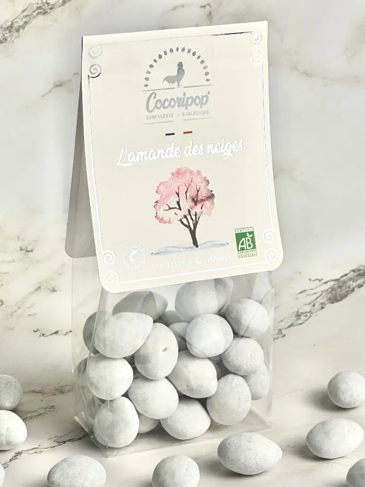 l'amande des neiges bio  – gourmandise raffinée alliant le croquant des amandes torréfiées, l’intensité du chocolat noir et la douceur d’une coque de sucre. Une mise en scène délicate pour une expérience gustative unique. bio