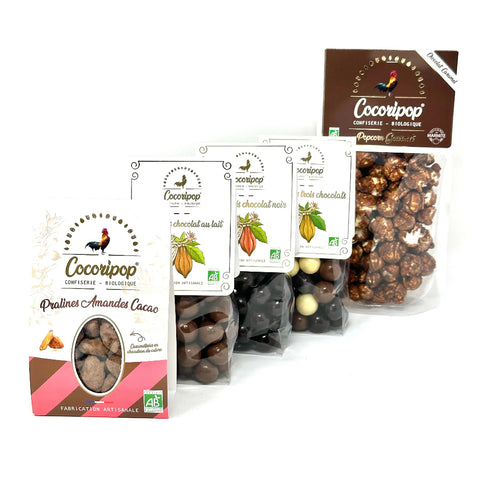 Le Pack tout choco Bio ! – assortiment gourmand de confiseries au chocolat incluant popcorn chocolat caramel, soufflés chocolat noir, lait et trois chocolats, ainsi que pralines amandes cacao, présenté sur fond blanc. bio