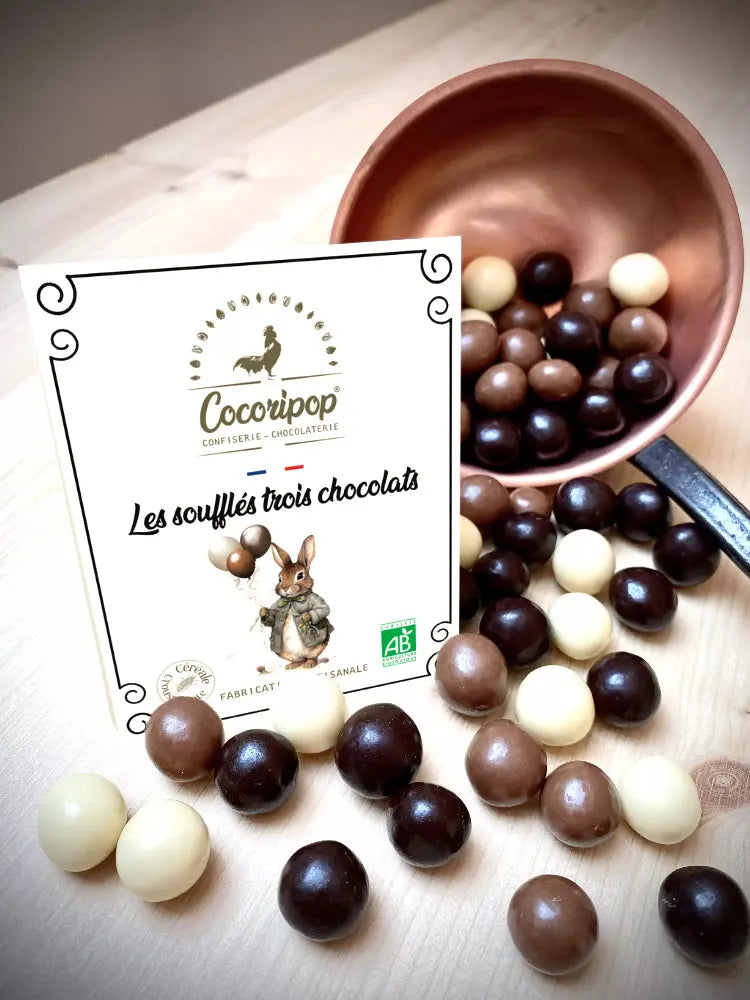 Gourmandises croquantes et fondantes avec les Soufflés Trois Chocolats version Lapin/Ballon Bio – un assortiment festif aux chocolats lait, noir et blanc, parfait pour Pâques.