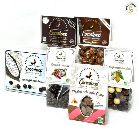 Pack Grand Mix Tout Chocolat Bio – assortiment gourmand de chocolats artisanaux incluant coffret métal trois chocolats, popcorn chocolat noir et caramel, soufflés trois chocolats, raisins chocolat noir et pralines amandes cacao, présenté sur fond blanc. bio