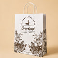 Sac kraft personnalisé Cocoripop pour emballage cadeau, parfait pour offrir des chocolats artisanaux, popcorn bio et gourmandises françaises.