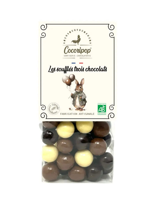 Soufflés Trois Chocolats version Lapin/Ballon "Sélection de Pâques" Bio – assortiment de soufflés croustillants enrobés de chocolat au lait, noir et blanc, présenté sur fond blanc.