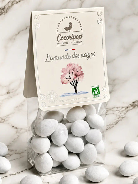 L'Amande des Neiges bio, amandes torréfiées enrobées de chocolat noir bio, de chocolat au lait bio et délicatement dragéifiées, fabriquées artisanalement près de Bourges dans le Berry par Cocoripop.