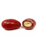 Amande croquante enrobée de chocolat saveur fraise, revêtue d’un enrobage rose délicat, sur fond blanc. oeufs du coq en chocolat BIO
