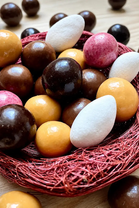 Confiserie artisanale française composée d'amandes dragéifiées et de billes de céréales croustillantes enrobées de chocolats bio, fabriquée à Saint-Germain-du-Puy.