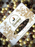 Coffret gourmand composé de noisettes torréfiées enrobées de chocolat noir bio, chocolat au lait bio et chocolat blanc bio, fabrication artisanale française à Saint-Germain-du-Puy.