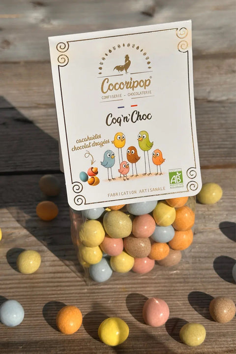 Confiserie artisanale française composée de cacahuètes bio enrobées de chocolat noir et chocolat au lait puis dragéifiées naturellement avec des colorants d'origine végétale.