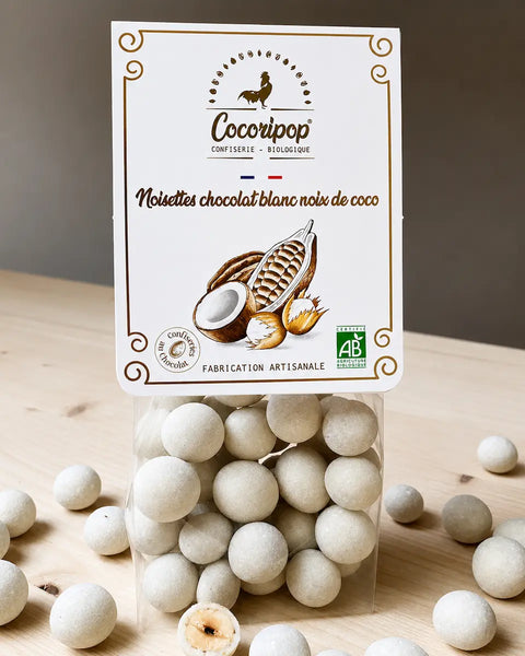 Noisettes torréfiées enrobées de chocolat blanc bio et de noix de coco râpée, fabriquées artisanalement près de Bourges dans le Berry par Cocoripop.