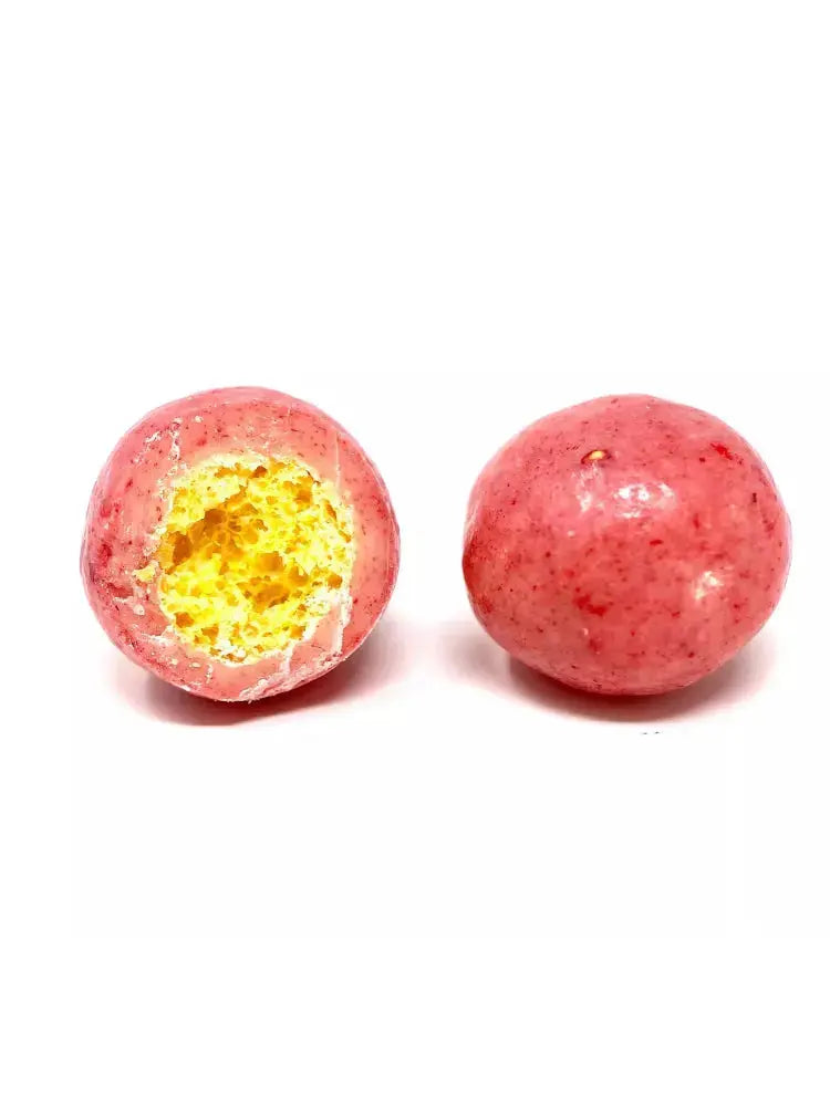 Bille croustillante enrobée de chocolat blanc infusé à la fraise, offrant une texture légère et un goût délicatement sucré, sur fond blanc. bio