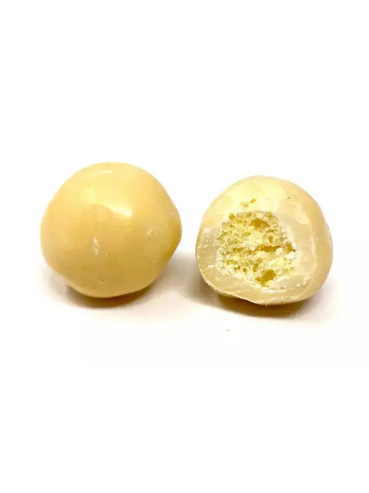 Bille soufflée croustillante enrobée de chocolat mangue, habillée d’une teinte jaune lumineuse, sur fond blanc. BIO